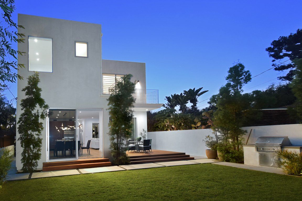 A white house with a large lawn in front of it