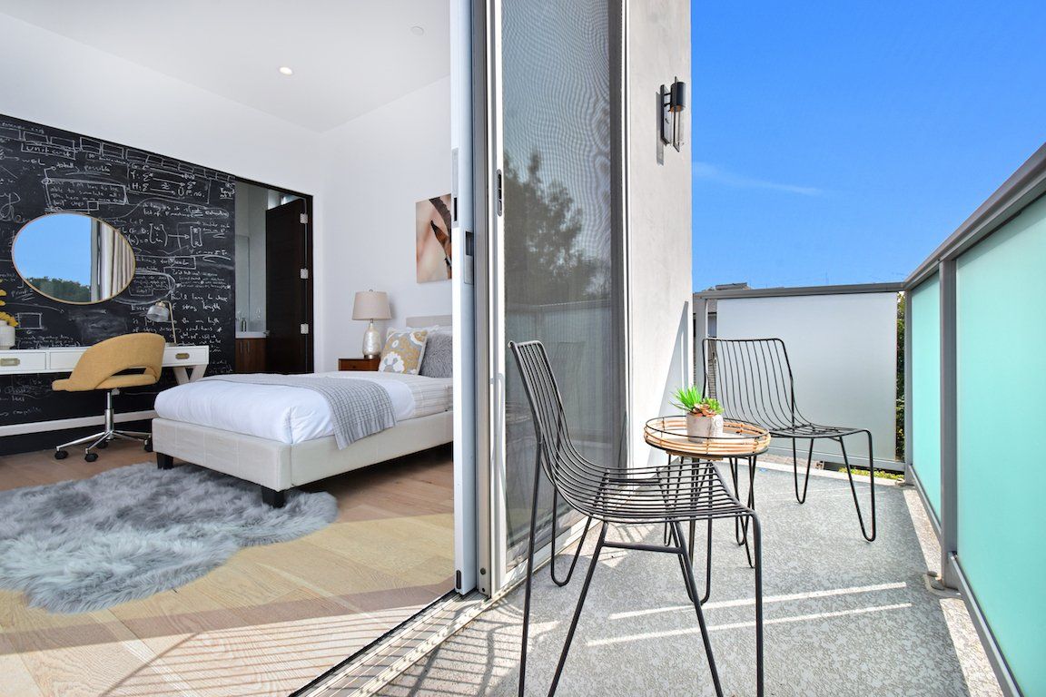 A bedroom with a balcony and a bed.