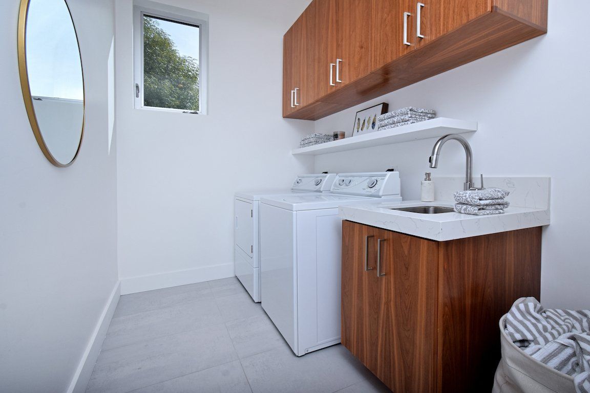 A laundry room with a washer and dryer and a sink.