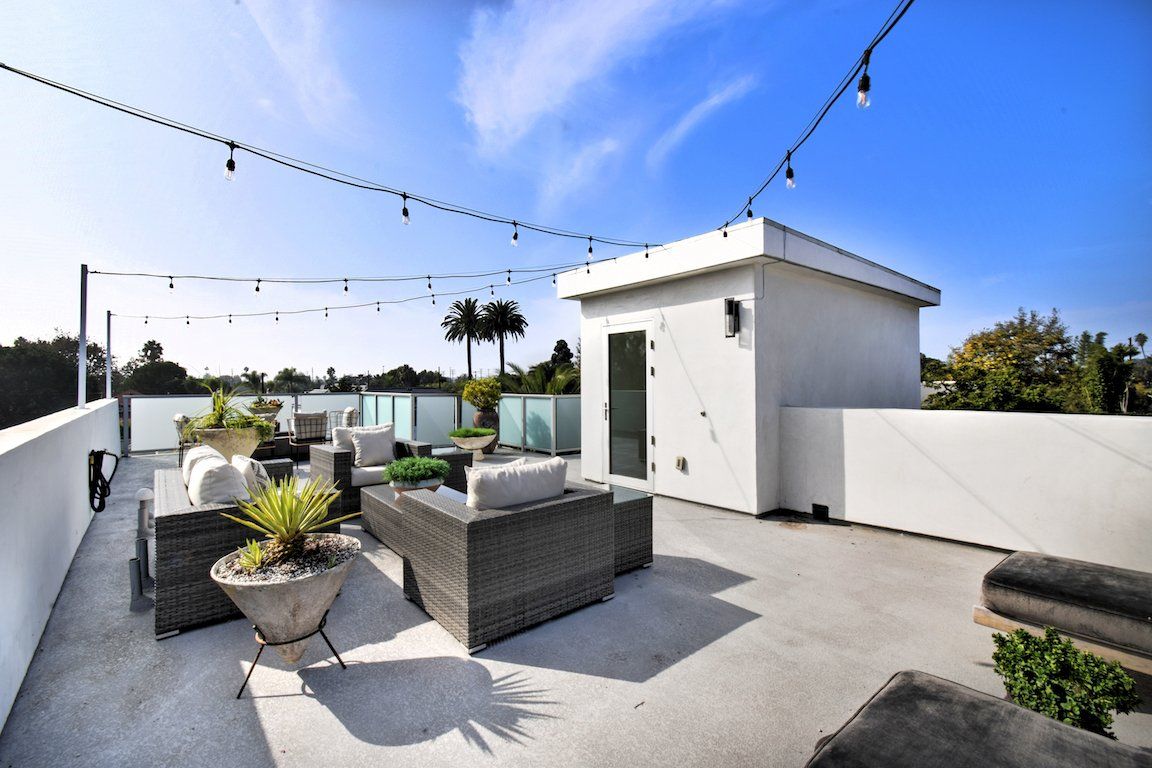 A rooftop deck with a lot of furniture on it
