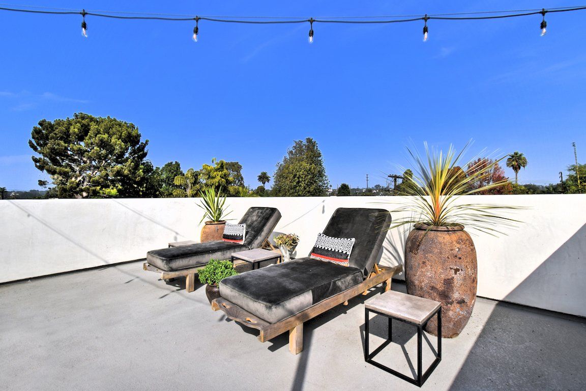 There are two lounge chairs on the roof of a building.