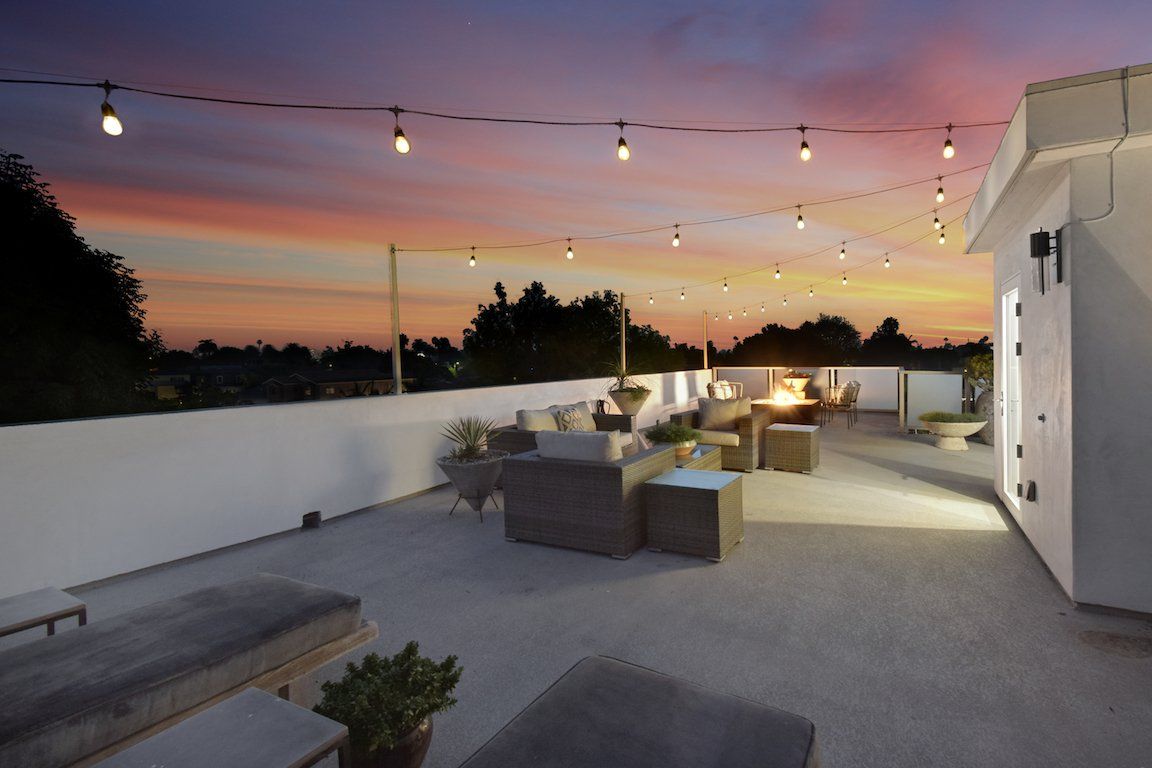 A rooftop deck with a sunset in the background