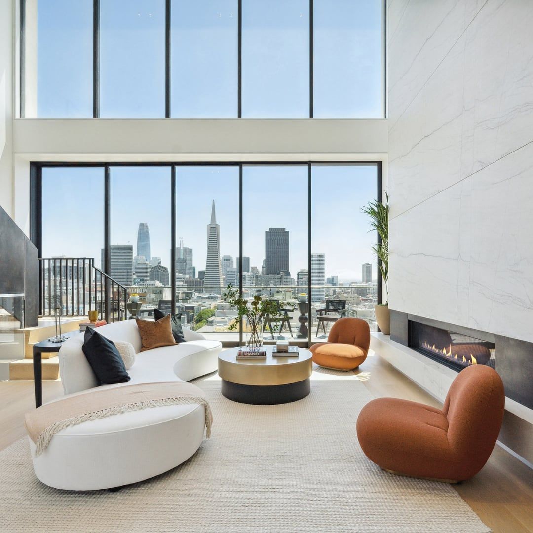 A living room with a fireplace and a view of the city