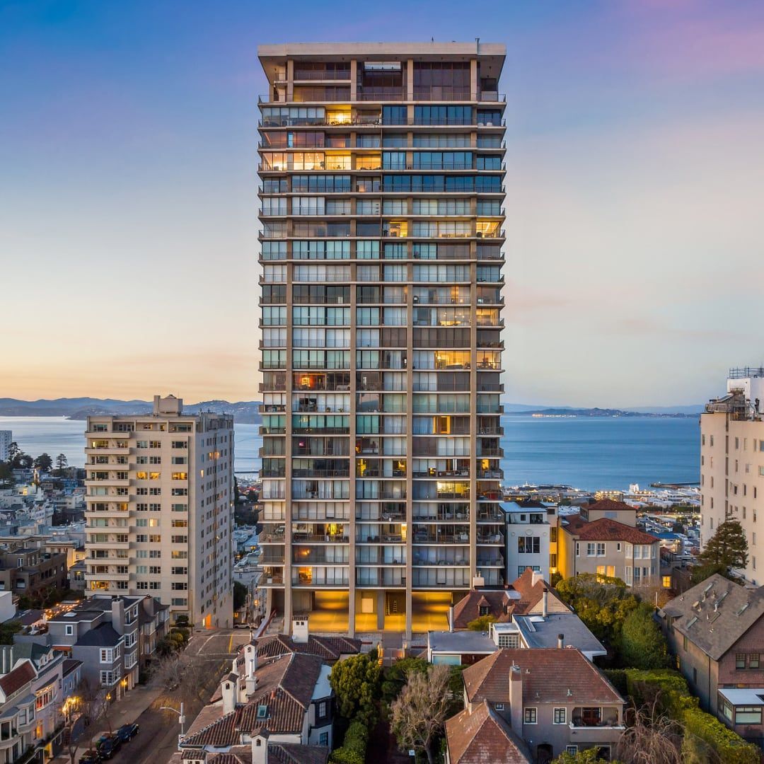 An aerial view of a city with a tall building in the foreground