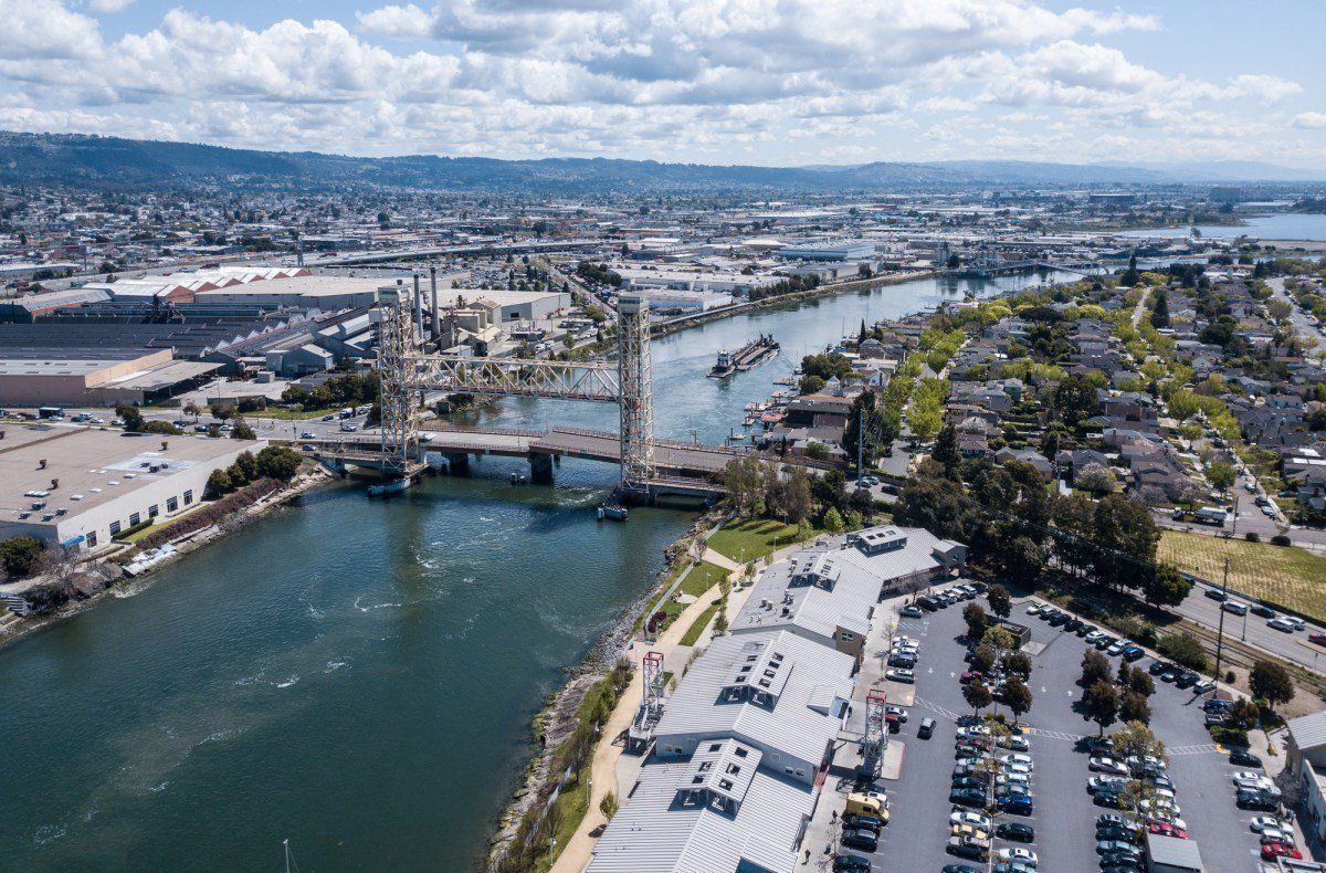 An aerial view of a city with a bridge over a river and a parking lot.