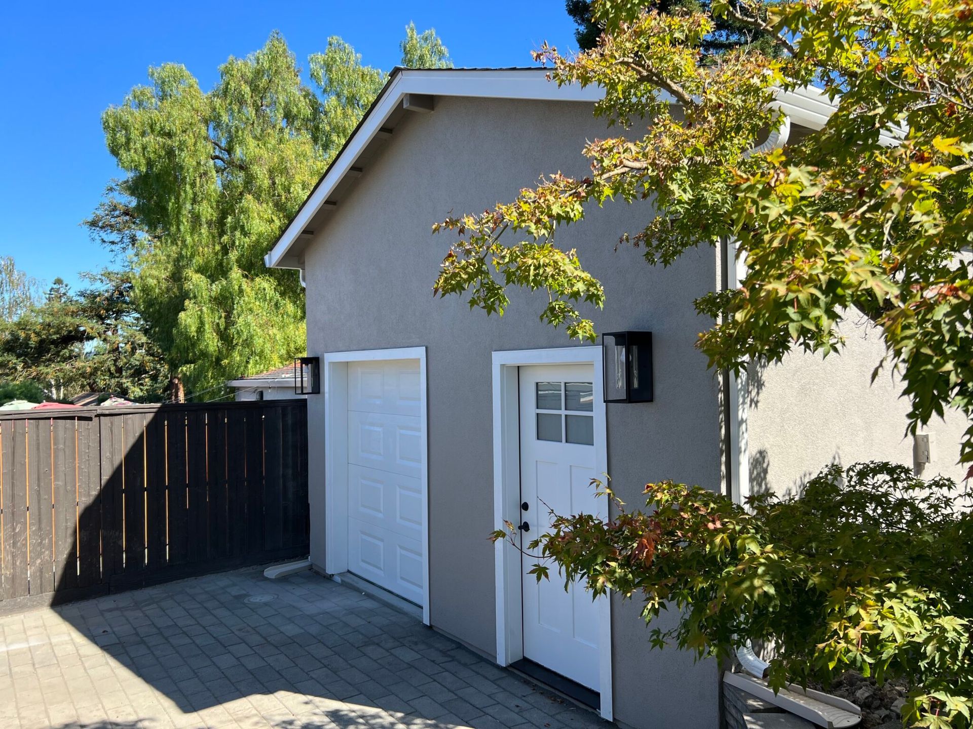 A garage with a white door and a black fence