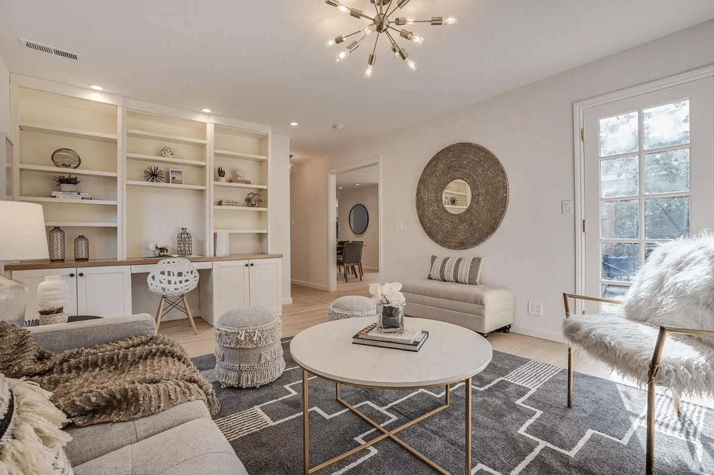 A living room with a couch , chair , coffee table and shelves.