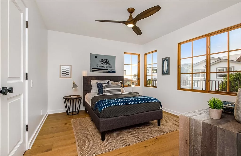 A bedroom with a large bed and a ceiling fan