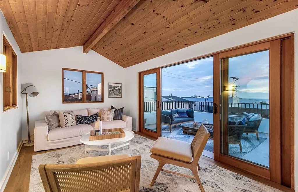 A living room with a couch , chairs , and sliding glass doors.