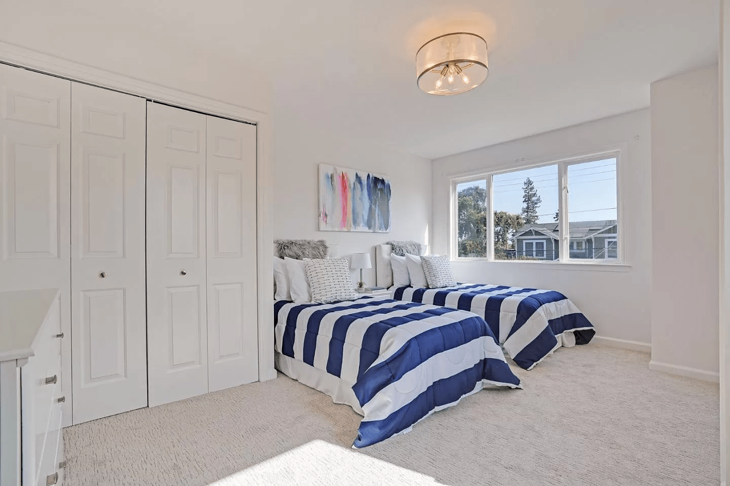 A bedroom with two twin beds and a window.