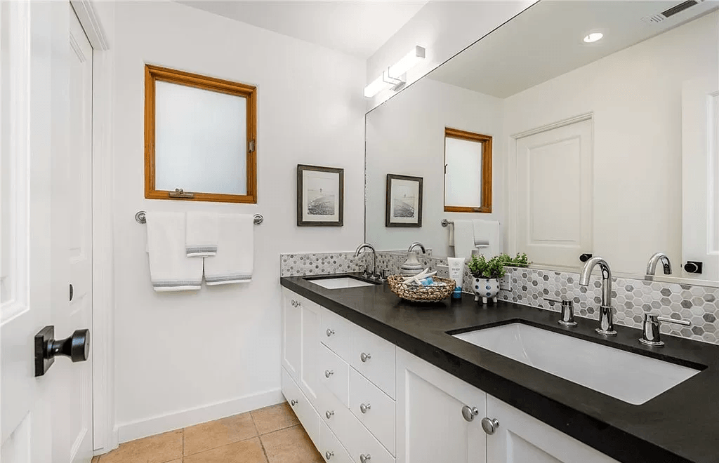 A bathroom with two sinks and a large mirror