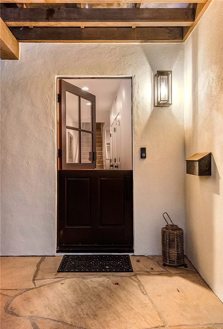 The front door of a house is open and looking into the living room.