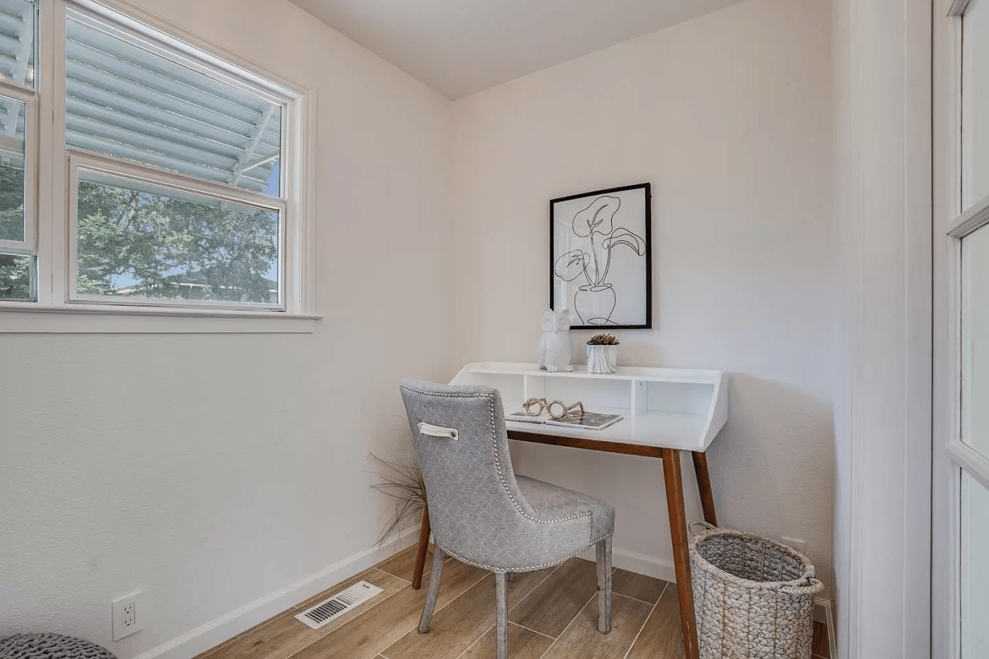 There is a desk and chair in the corner of the room.