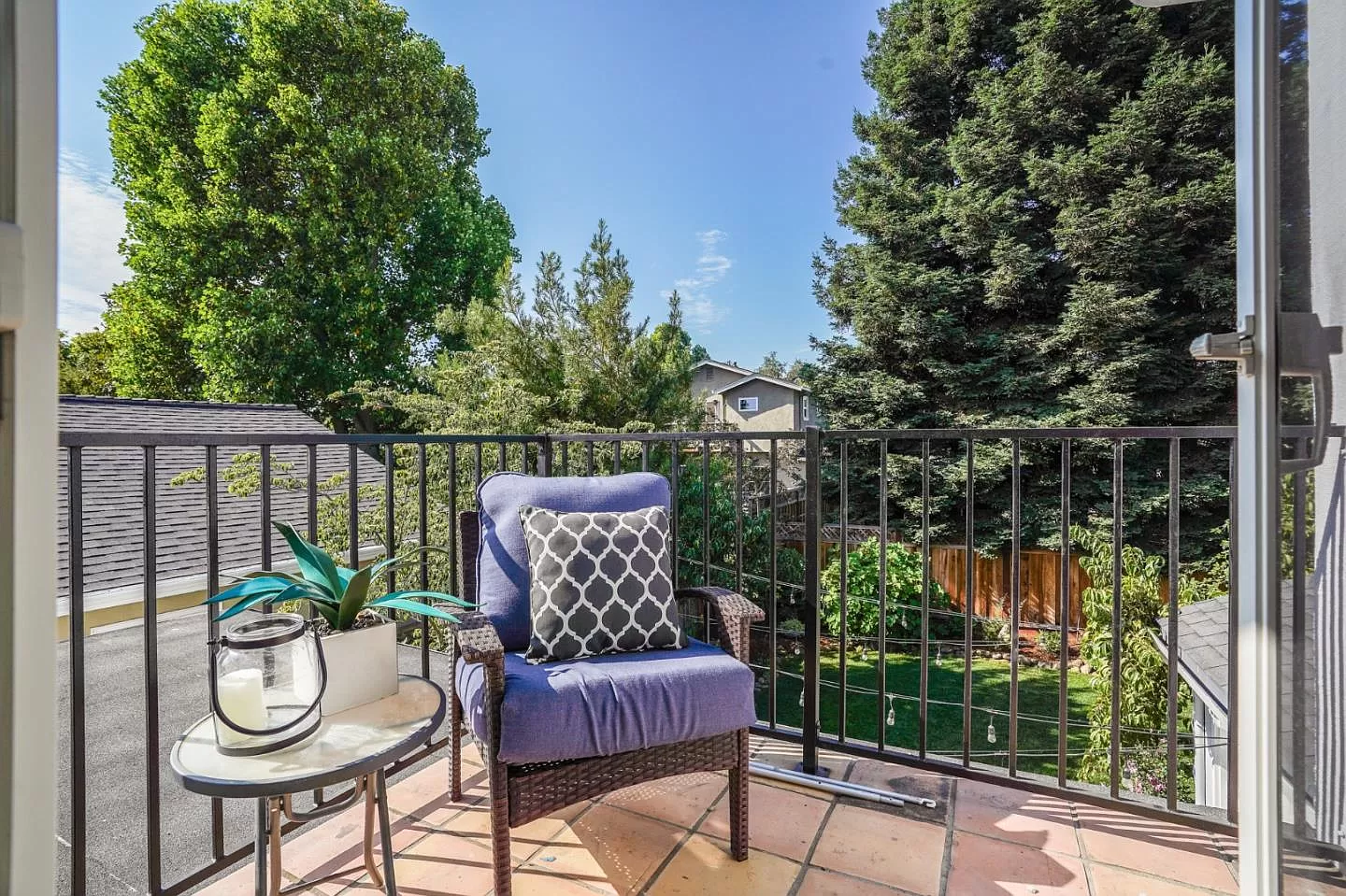 There is a chair and a table on the balcony.