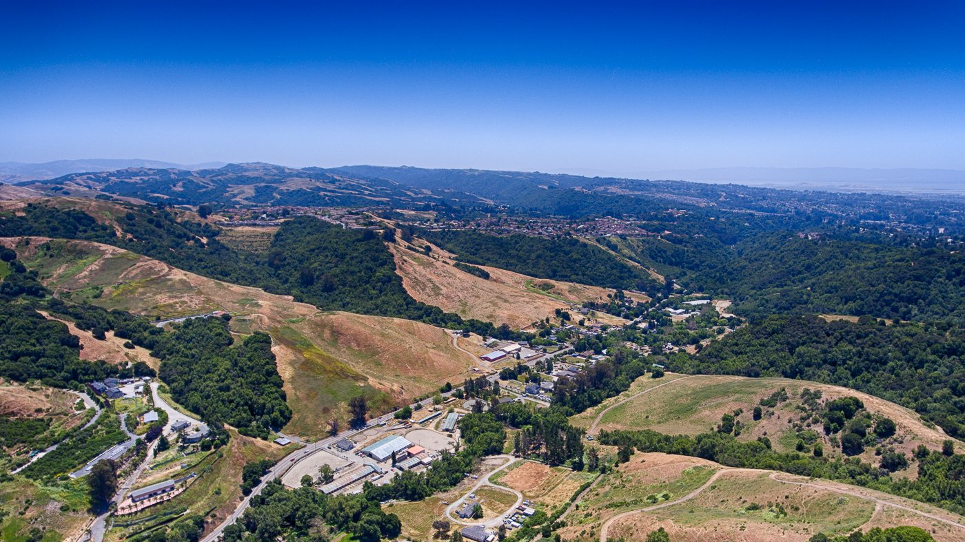 An aerial view of a valley surrounded by mountains and trees.