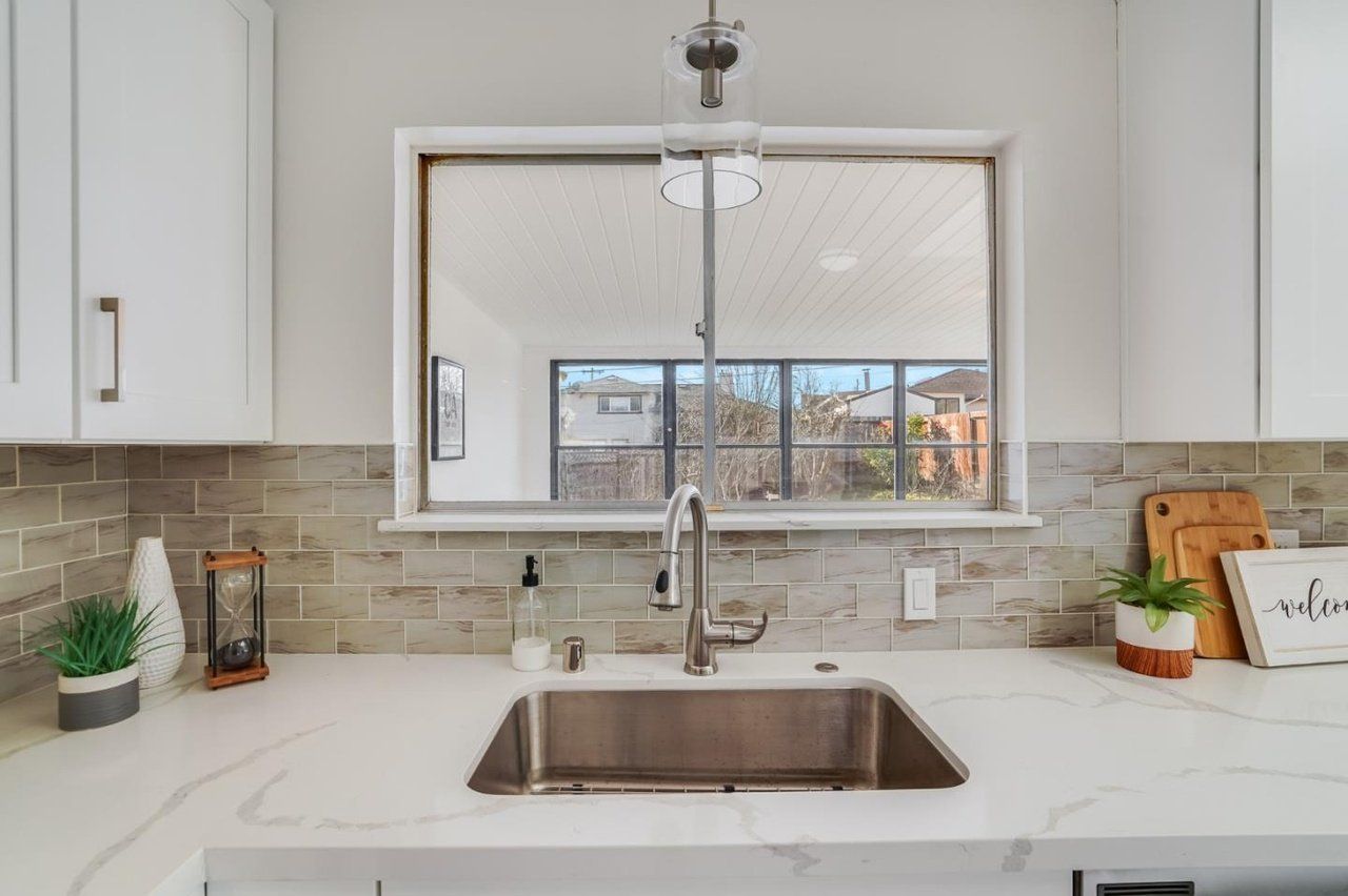 A kitchen with a stainless steel sink and a window.