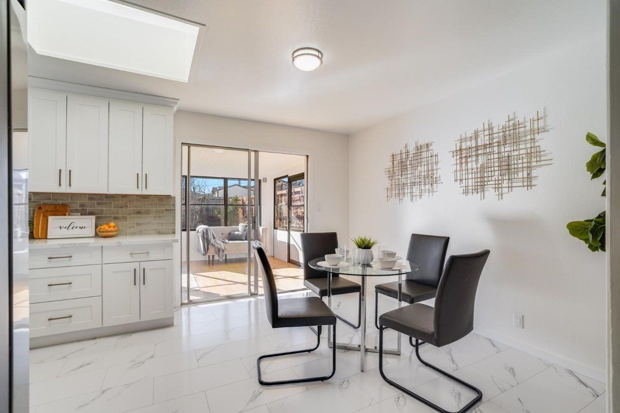 A dining room with a table and chairs in a kitchen.