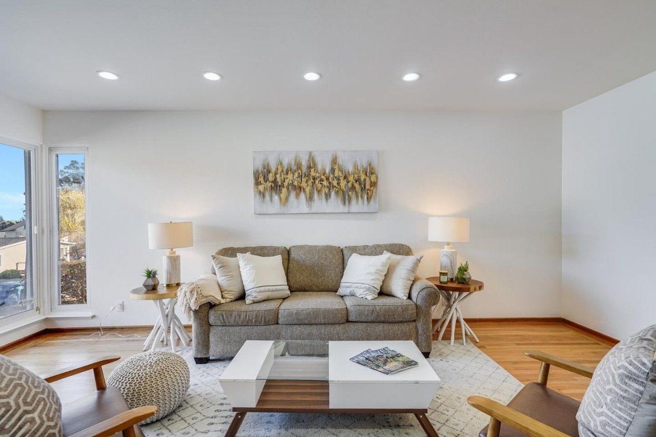 A living room with a couch , chairs , and a coffee table.