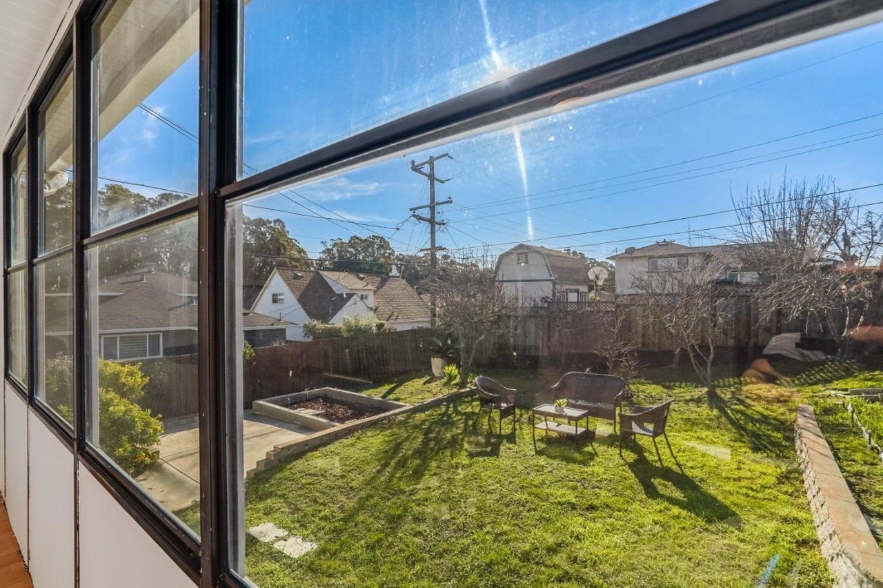 A view of a backyard through a window with a lot of windows.