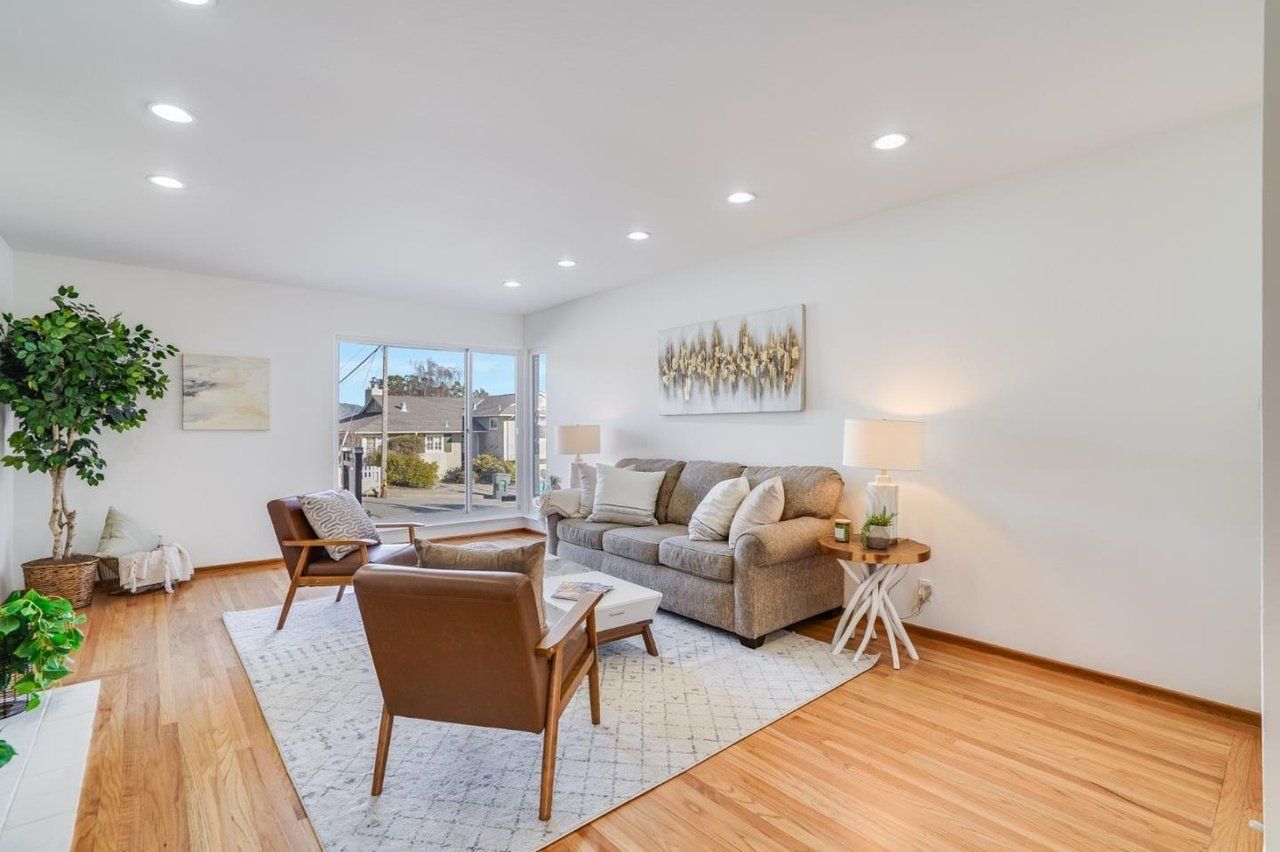 A living room with a couch , chairs , and a rug.