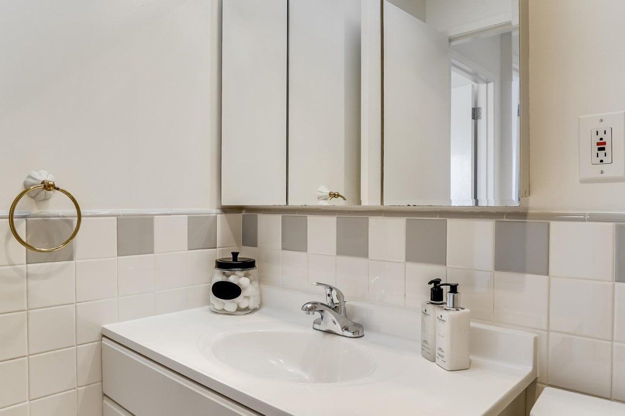 A bathroom with a sink , toilet and mirror.