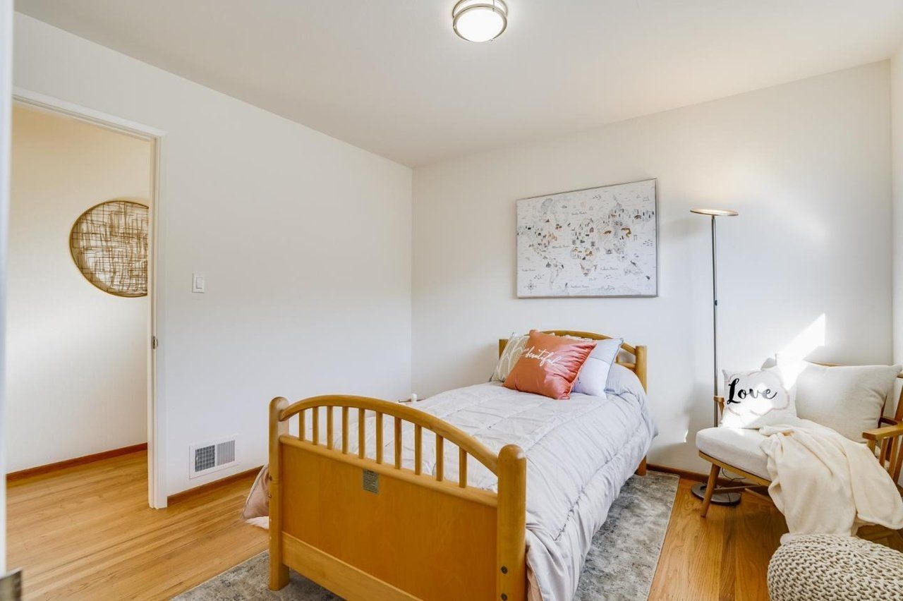 A bedroom with a single bed and a chair.