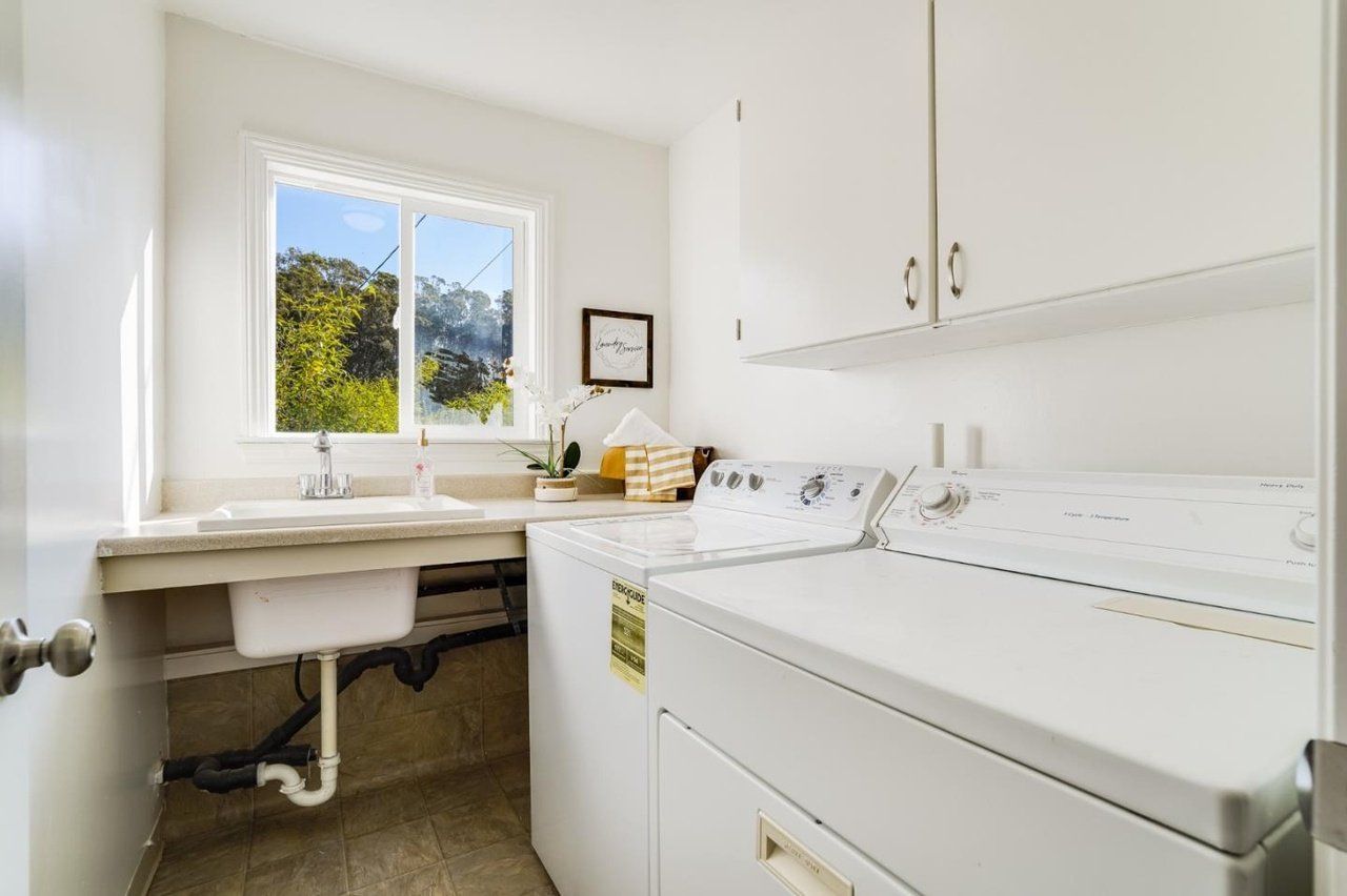 A laundry room with a washer and dryer and a sink.