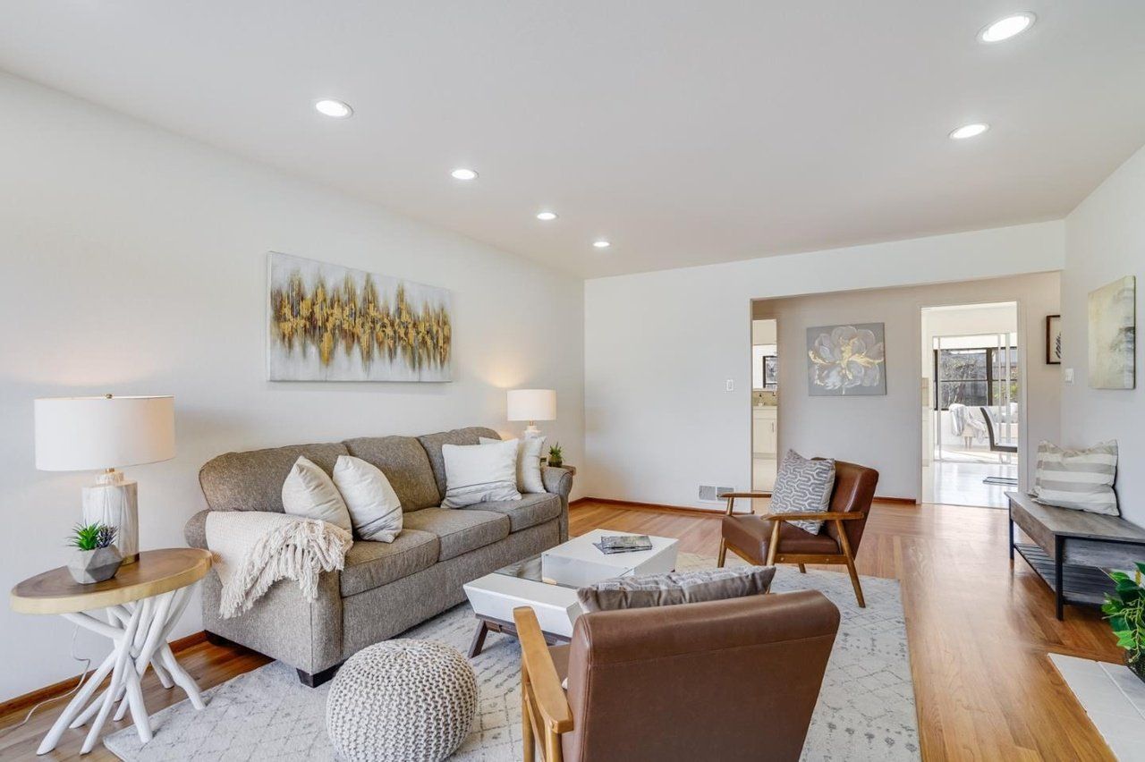 A living room with a couch , chairs , and a coffee table.