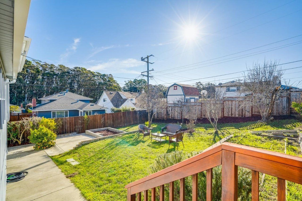 A view of a backyard from the deck of a house.