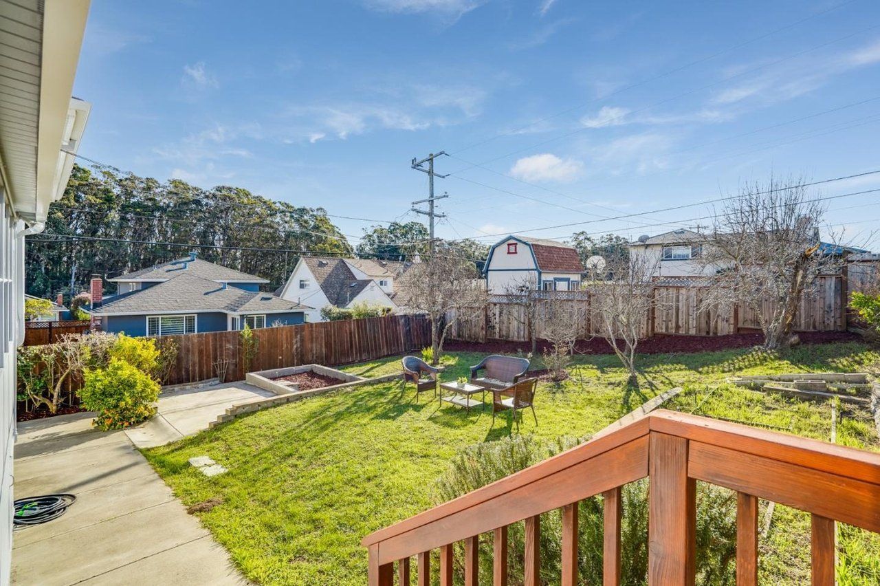 A view of a backyard from the deck of a house.