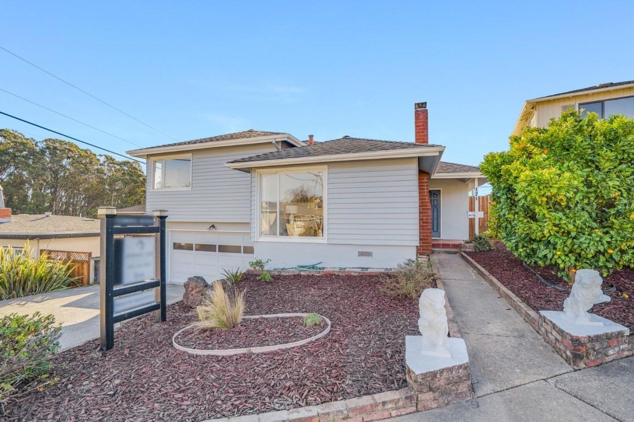 A house with a sign in front of it is for sale.