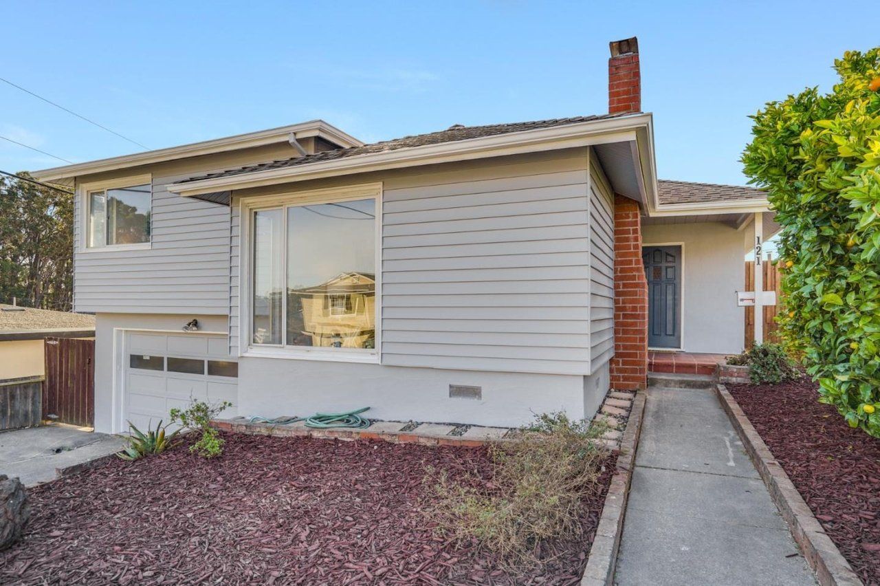 A small white house with a brick chimney