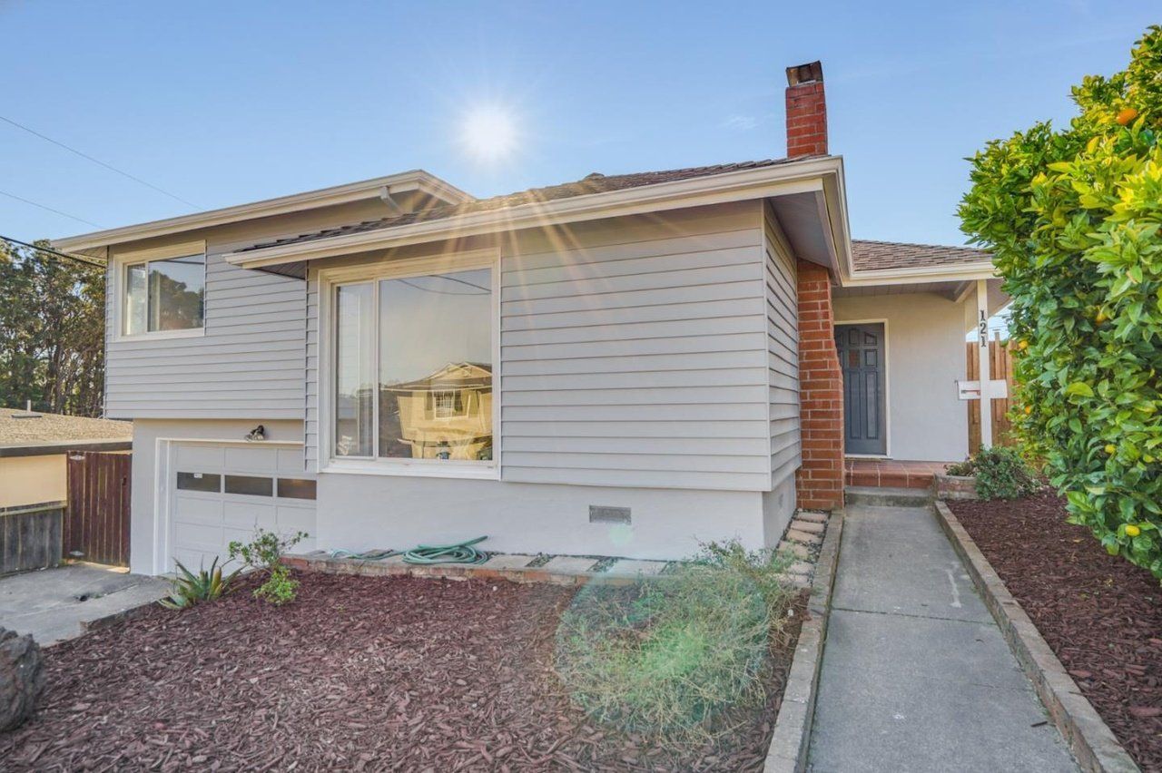 A white house with a brick chimney is for sale