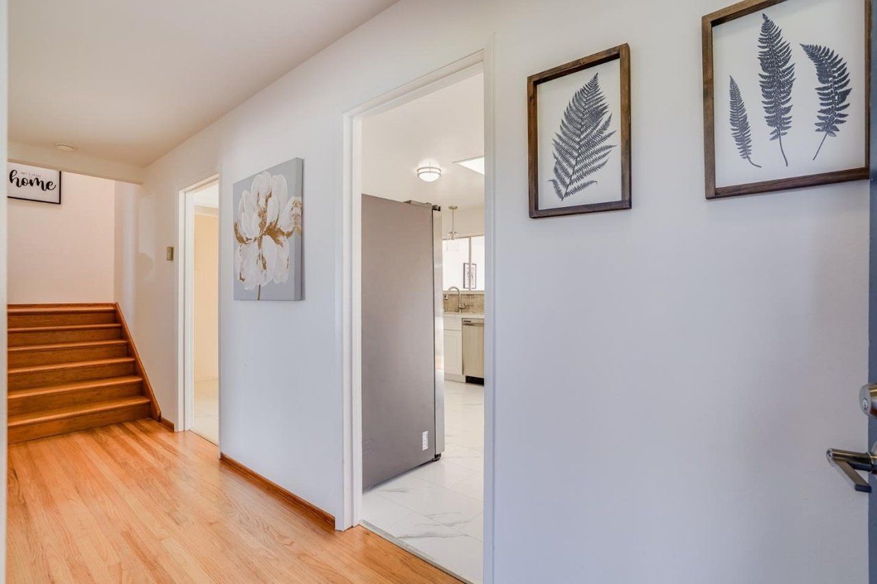 A hallway with stairs leading up to the second floor of a house.