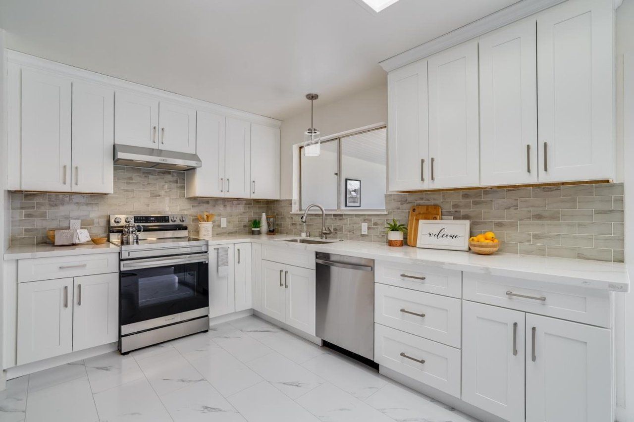A kitchen with white cabinets and stainless steel appliances.