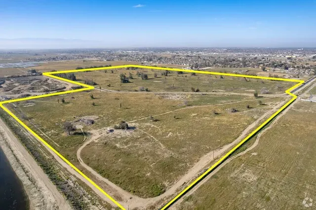 An aerial view of a large field with a yellow line around it.