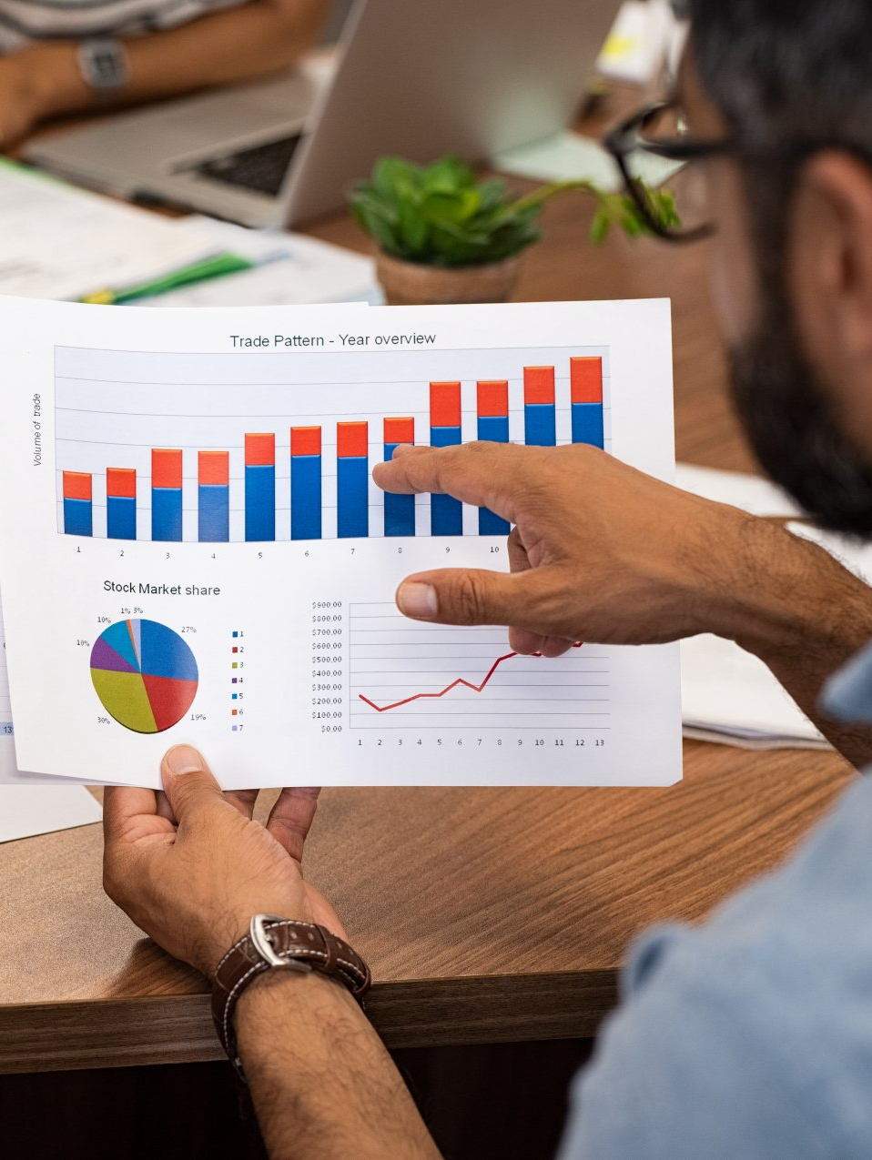 A man is pointing at a graph on a piece of paper.