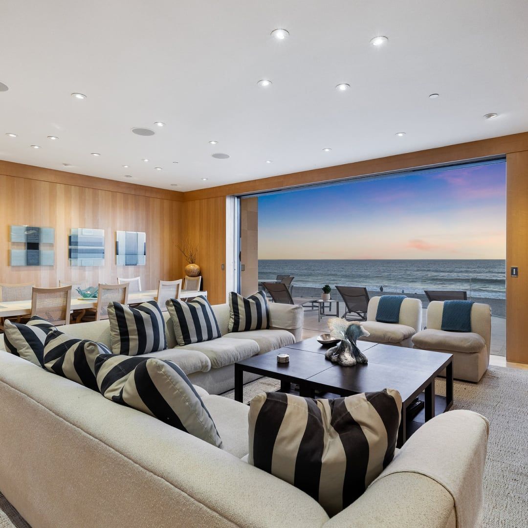 A living room with a couch and a table with a view of the ocean