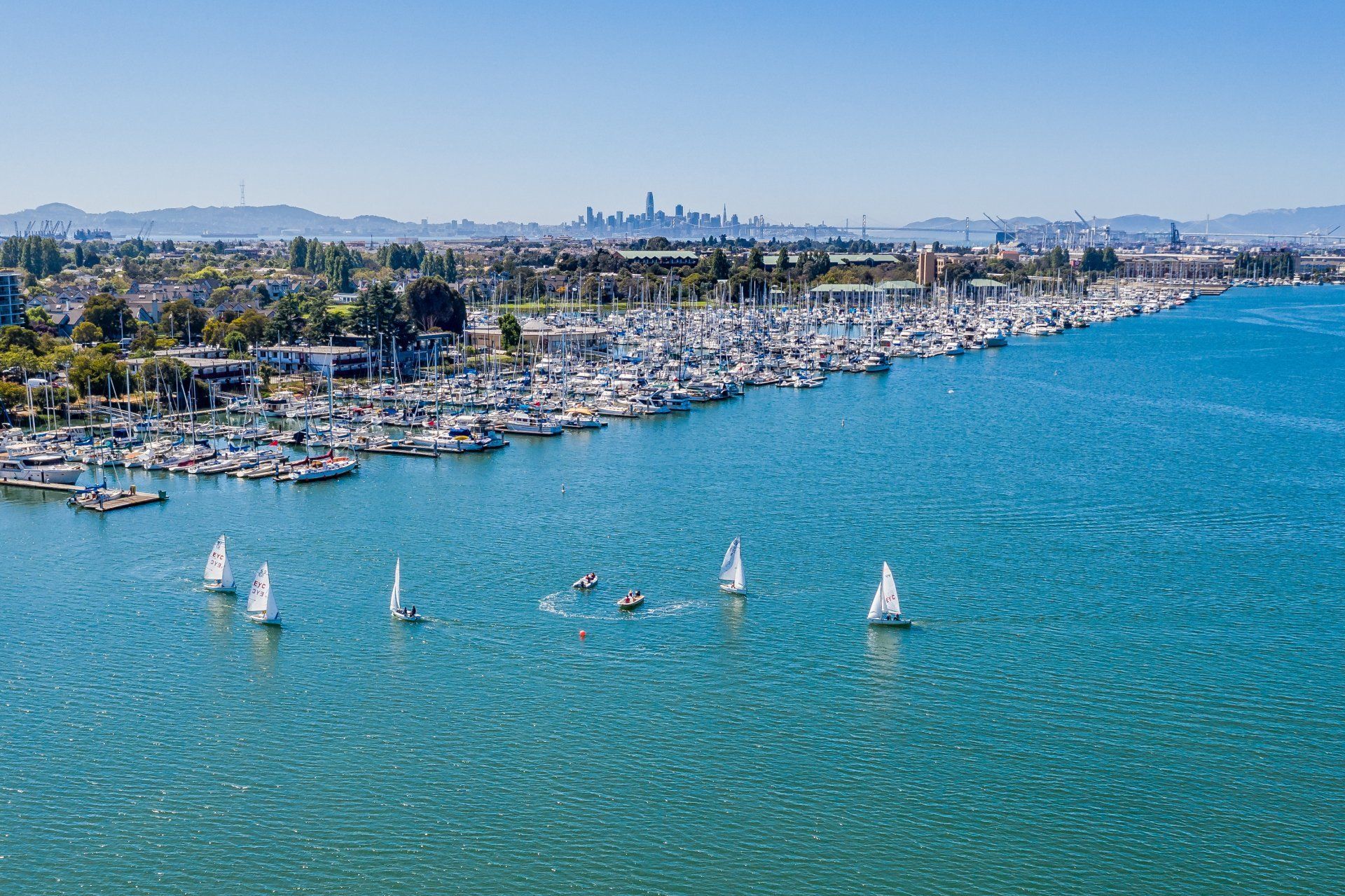 A group of sailboats are floating on top of a large body of water.