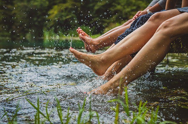 Women splashing feet in water — Tyler, TX — Foot Specialists of Tyler