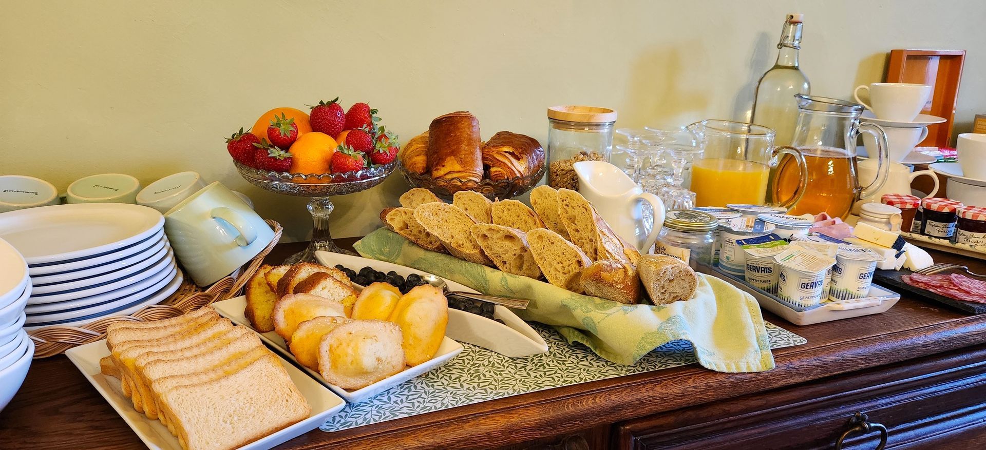 Chambre avec lit en bois orné, mur rouge, lustre et lampes de chevet.