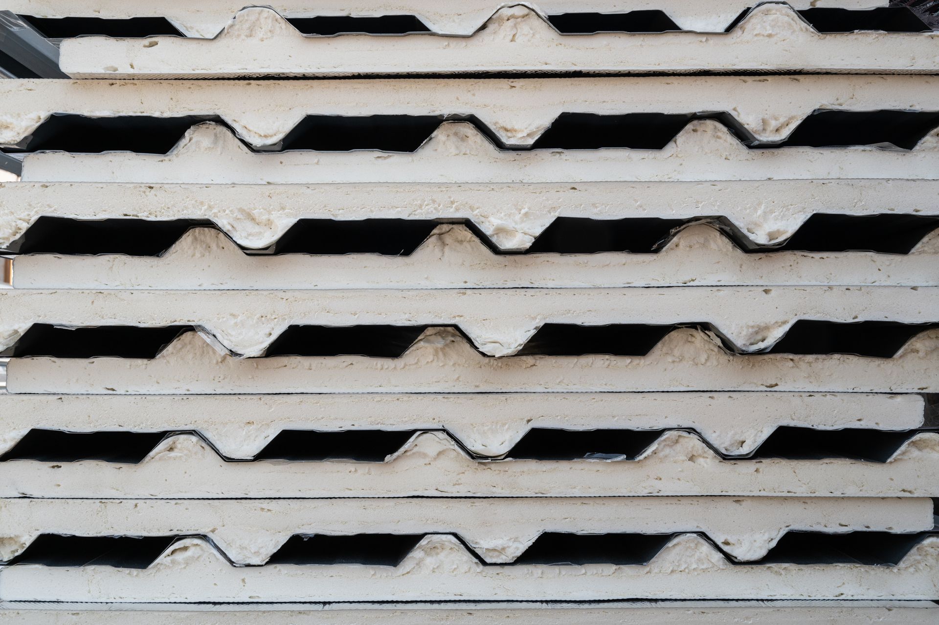 Stack of insulated corrugated metal roofing sheets with construction background. Stack of insulated corrugated metal roofing sheets with construction background.