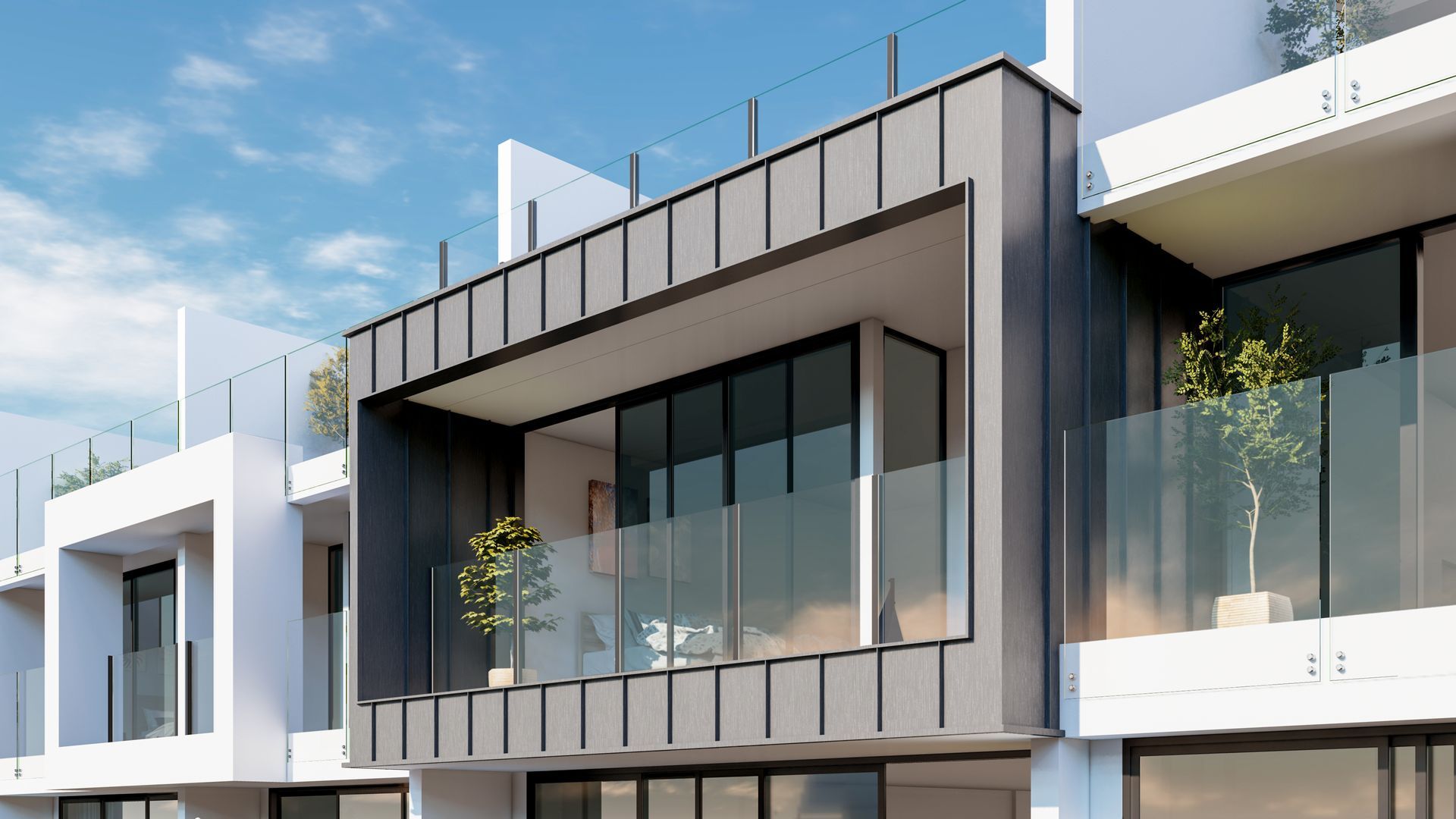 Modern townhouses with glass balconies and grey facade accents under a blue sky.