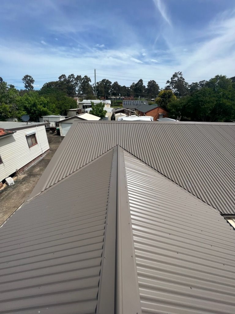 A man in a cowboy hat is working on a roof.