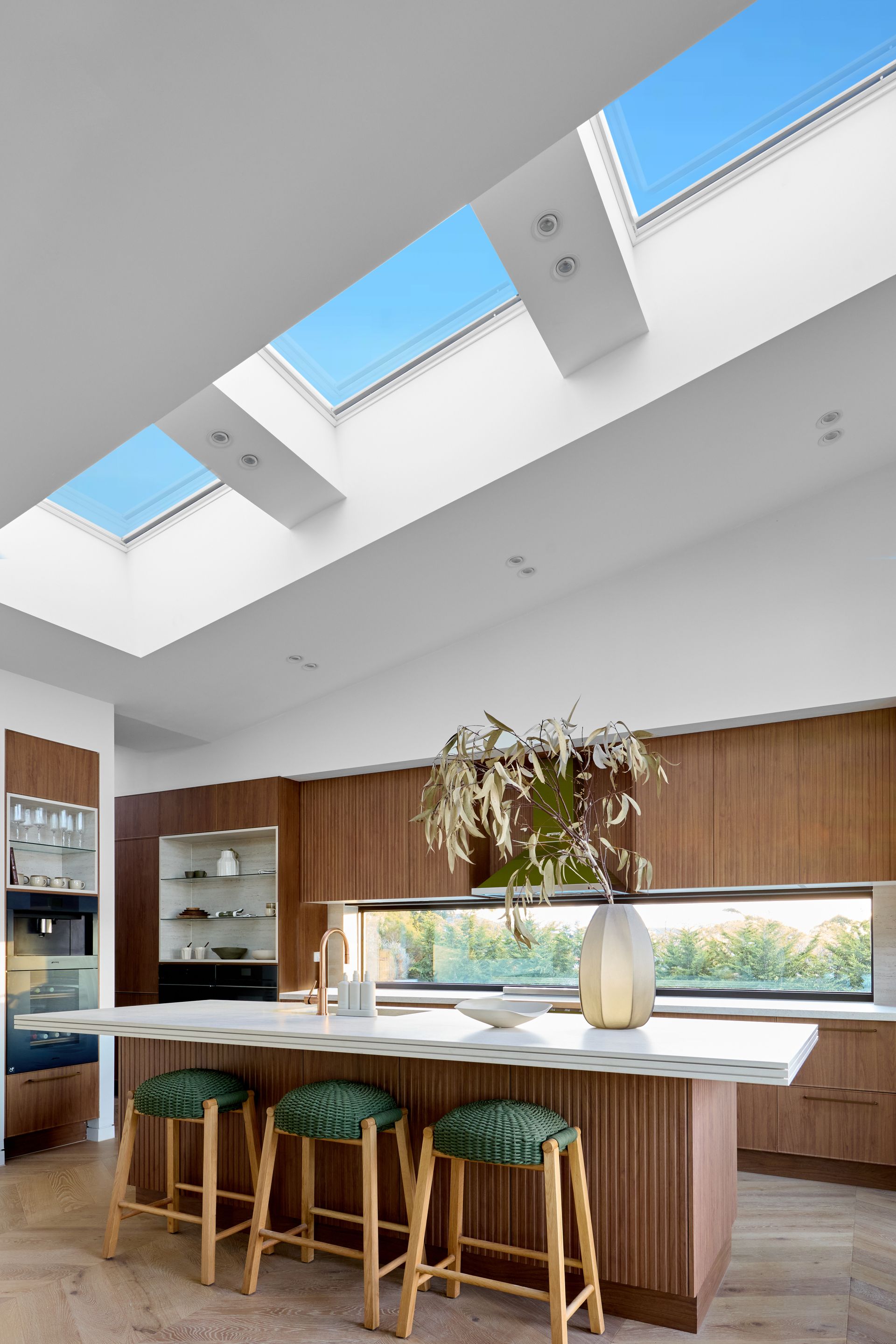 A kitchen with a large island and skylights above it.