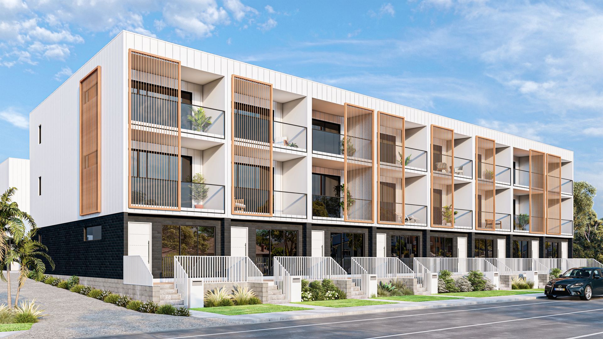Modern three-story building with wooden accents and balconies. Ground level storefronts. Bright blue sky.