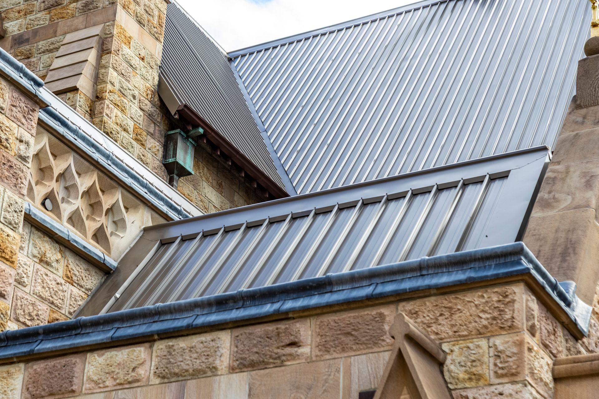 A stone building with a metal roof and a decorative stone pattern.