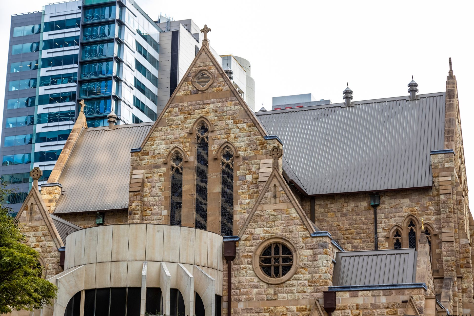 Stone church building with a modern building in the background.