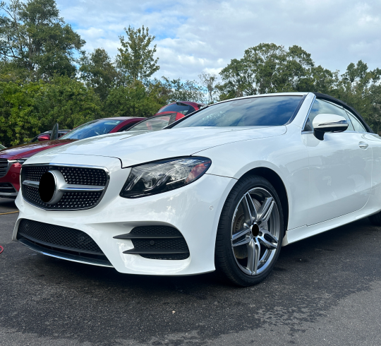 A Mercedes convertible is parked in a parking lot | BMW Car | In Stock Auto Outlet and Collision
