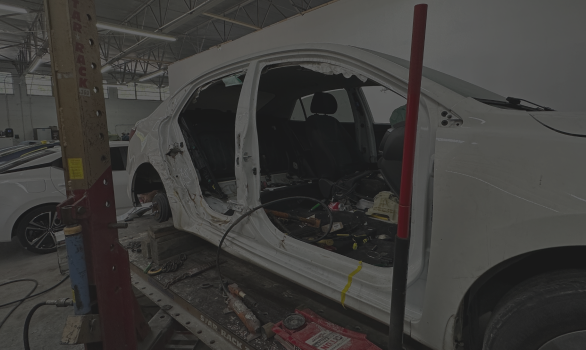 white car is being worked | In Stock Auto Outlet and Collision